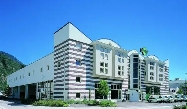 Sede corporativa da HGS com prédio moderno e frota de veículos